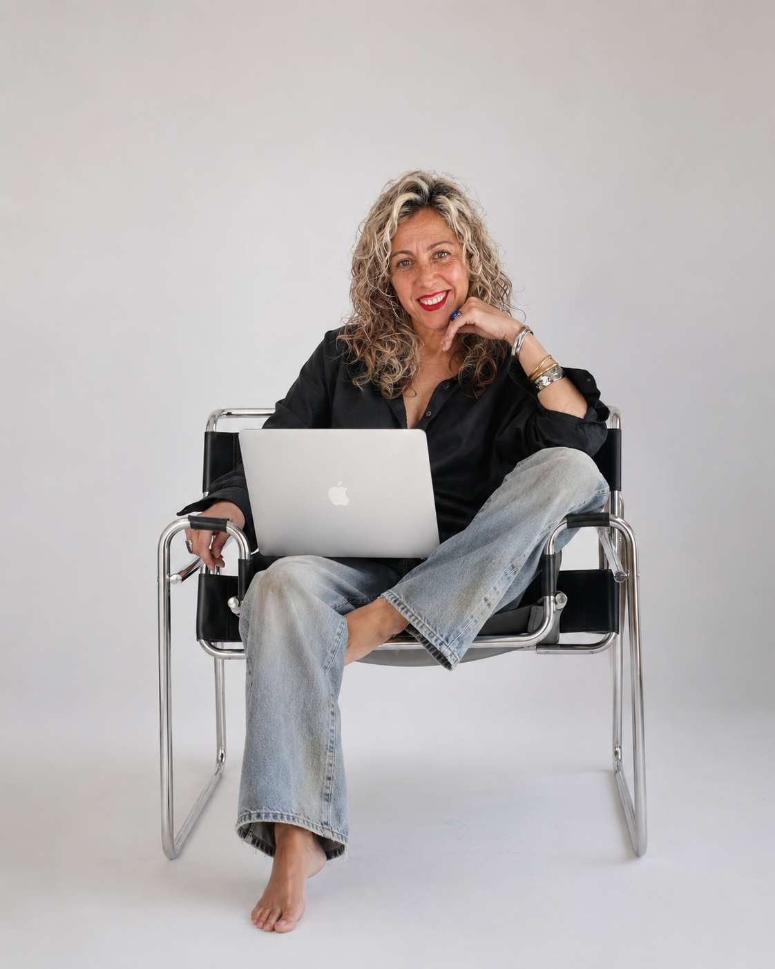 Raquel Cánovas en su estudio, sentada con su MacBook, directora creativa y estratega de marca detrás de RAW BRANDS